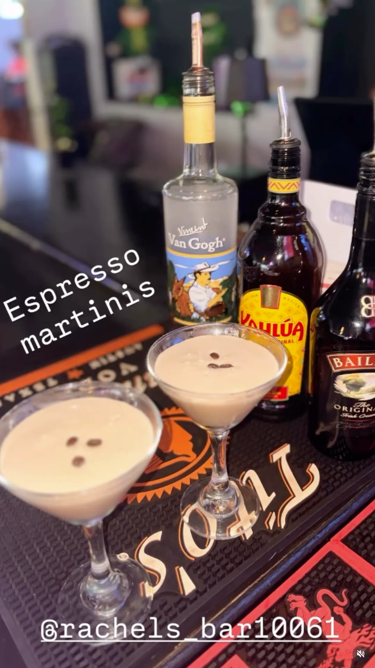 Two espresso martinis on the bar with crema on top.