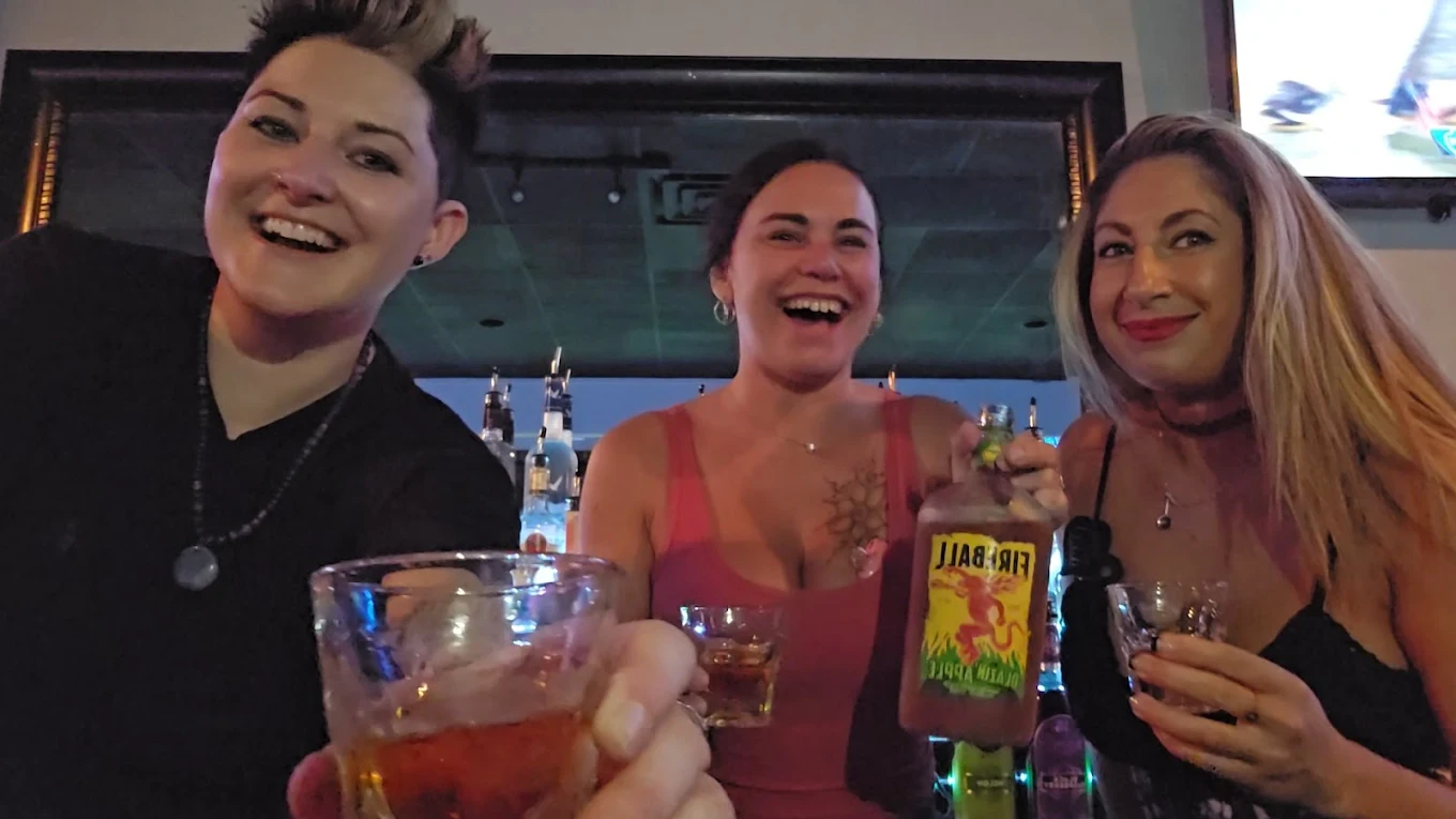 Three friends taking fireball shots at the bar.