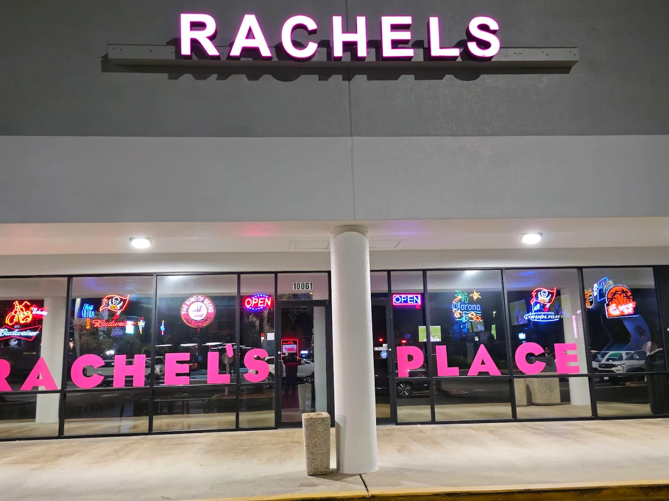 The pink-neon Rachel's Place storefront at 10061 W. Hillsborough Ave at night.